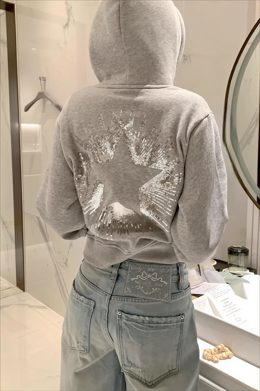 Cropped hooded pullover with long sleeves and a large sequin star design on the back