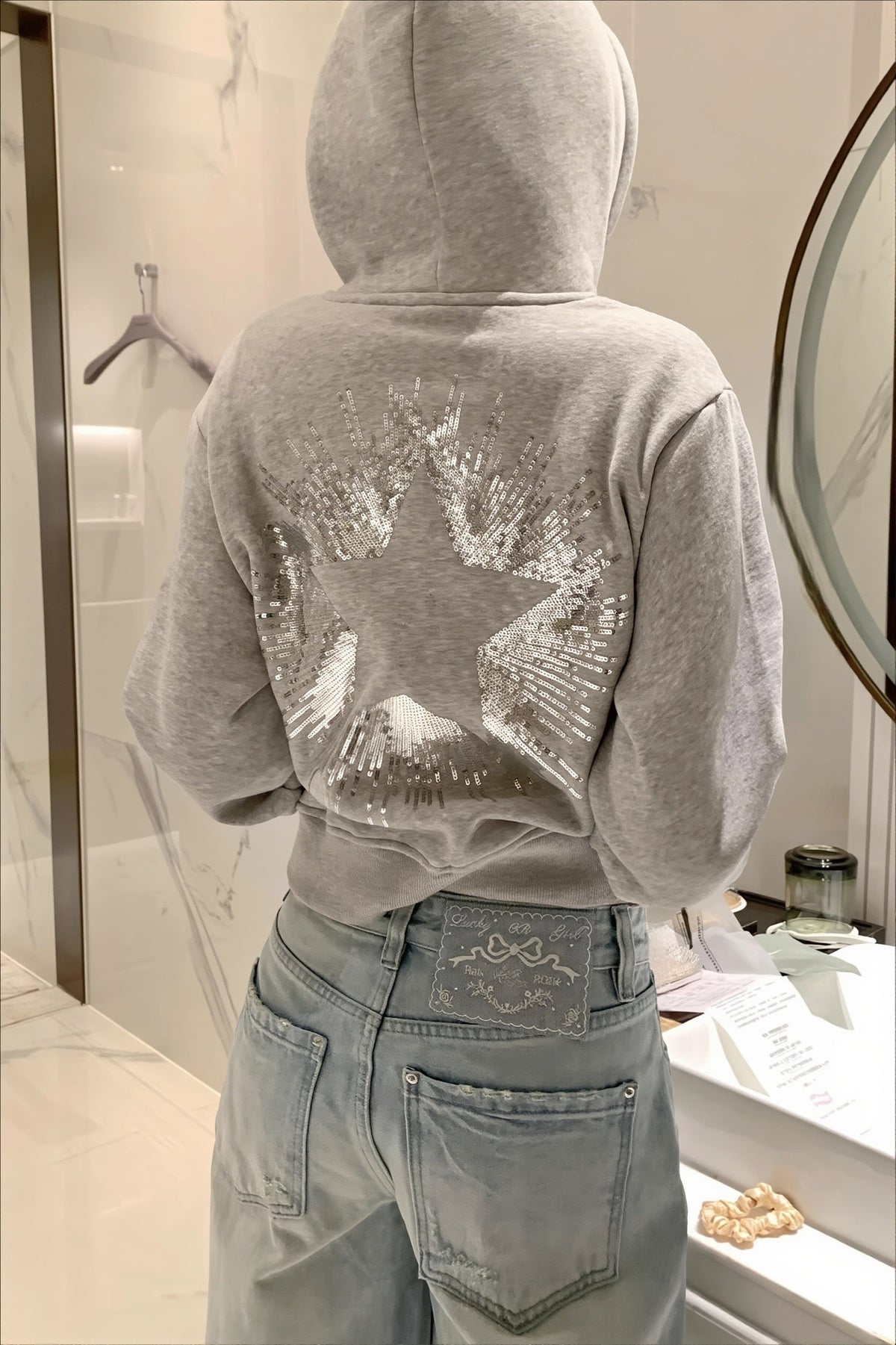 Cropped hooded pullover with long sleeves and a large sequin star design on the back