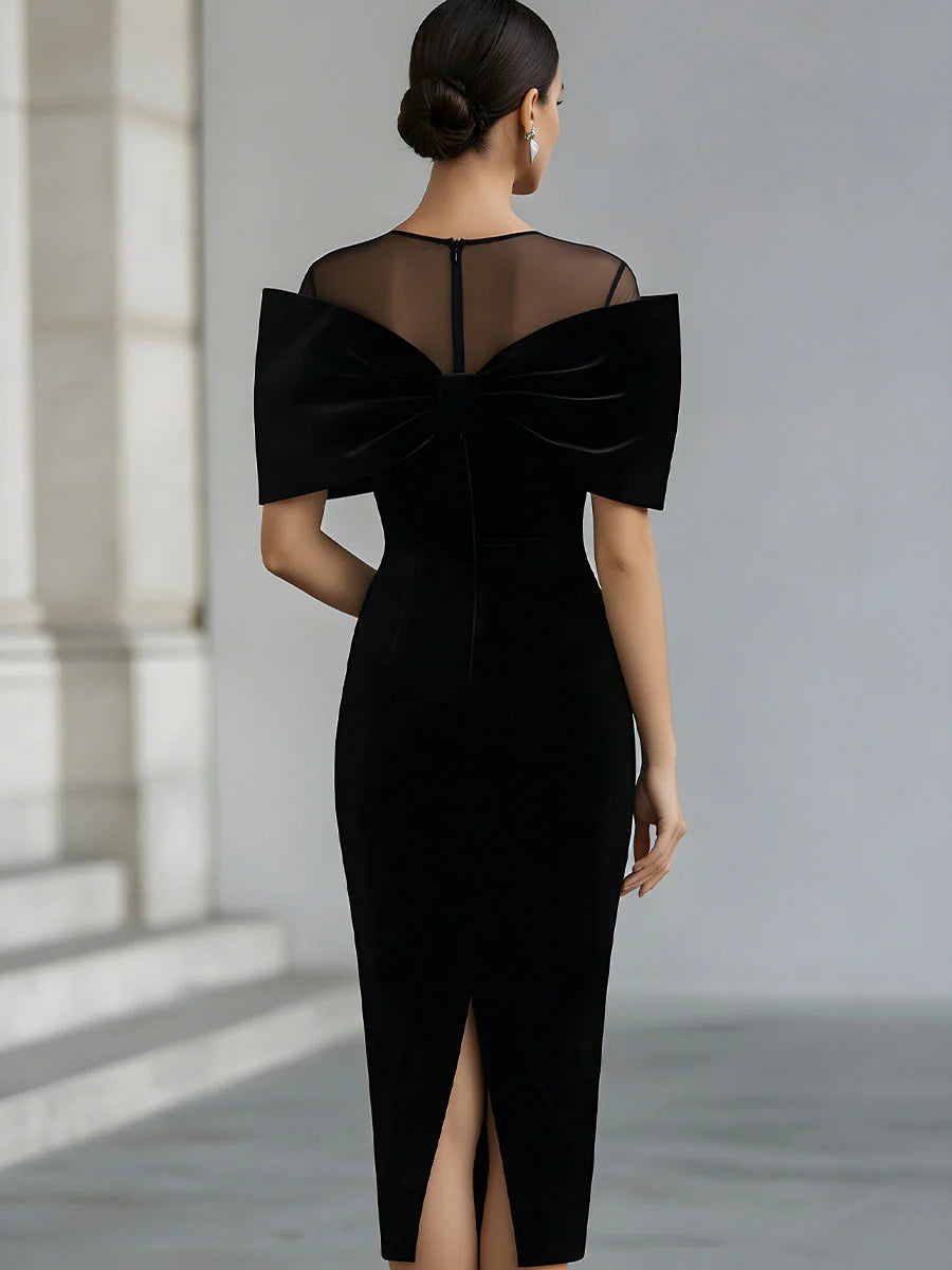 Women's black velvet midi dress with a large bow and sheer neckline
