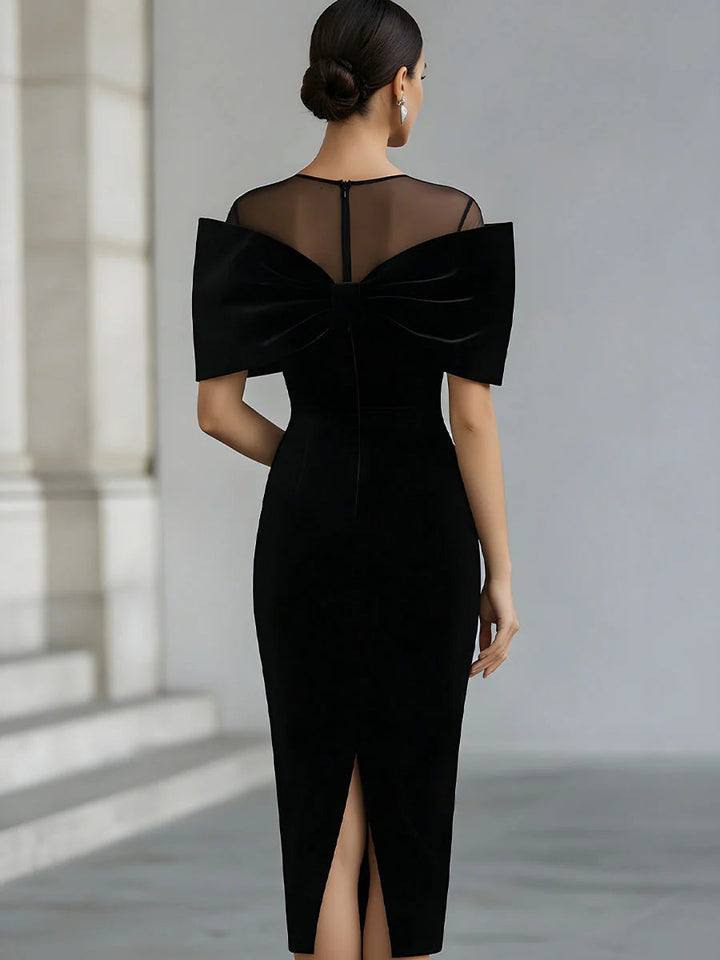 Women's black velvet midi dress with a large bow and sheer neckline