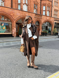 Women's brown long trench coat with wide lapels and cape-style sleeves