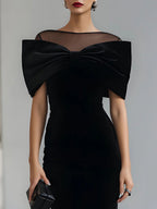 Women's black velvet midi dress with a large bow and sheer neckline
