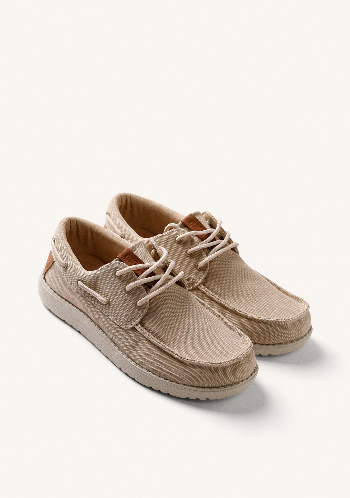 Beige canvas Wallabee loafers with lace-up fronts and moc toes