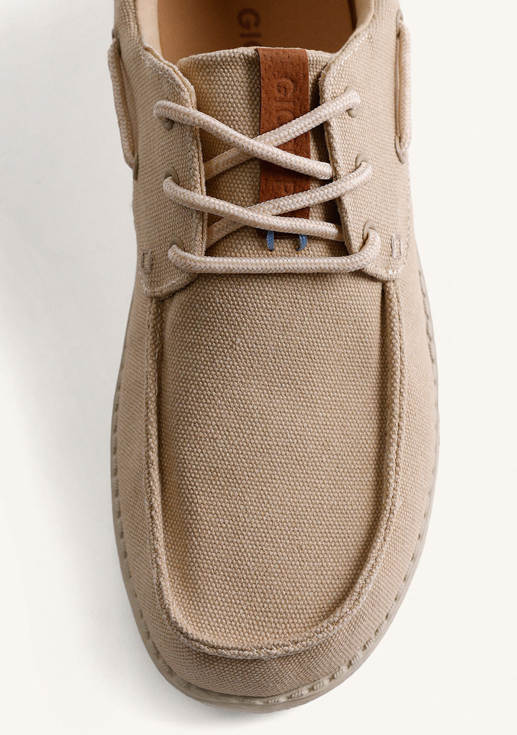 Beige canvas Wallabee loafers with lace-up fronts and moc toes