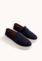 Navy slip-on penny loafers with decorative strap detail and contrasting flat soles