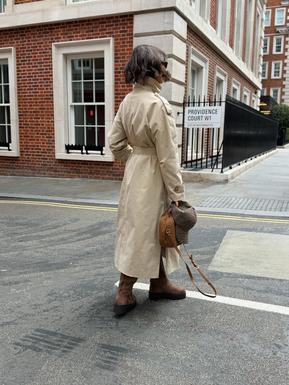 Women's beige long trench coat with high collar, buttons and tied waist belt