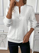 Women's textured cable knit sweater with round neckline and quarter-zip fastening