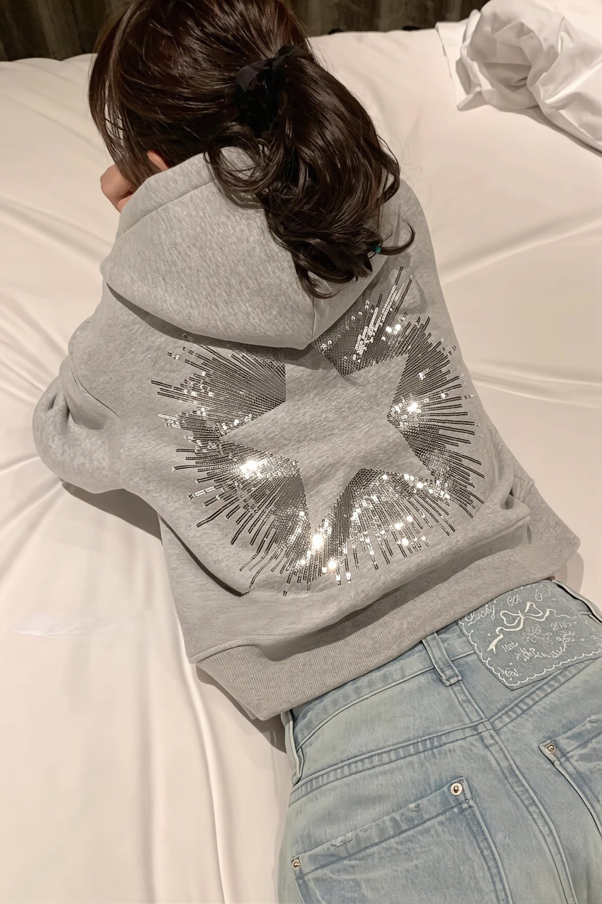 Cropped hooded pullover with long sleeves and a large sequin star design on the back