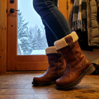Brown fur-lined ankle boots with cream cuffs and buckle details