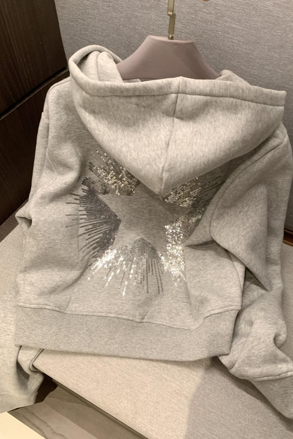 Cropped hooded pullover with long sleeves and a large sequin star design on the back