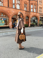Women's brown long trench coat with wide lapels and cape-style sleeves