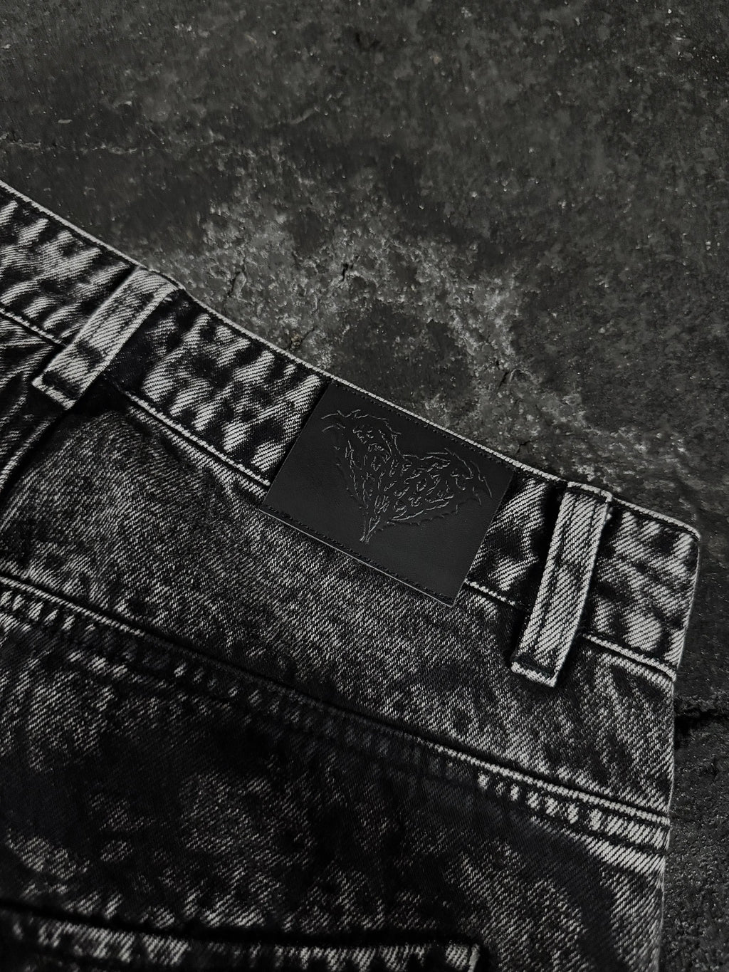 Women's black wide-leg jeans with graphic printed panels and flap pockets