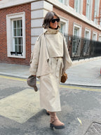Women's beige long trench coat with high collar, buttons and tied waist belt