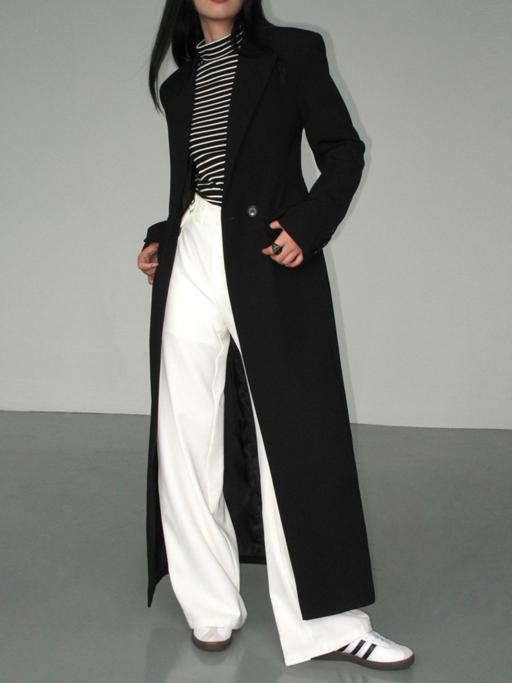 Women's long black tailored coat with lapels and one-button closure
