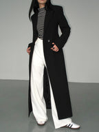 Women's long black tailored coat with lapels and one-button closure