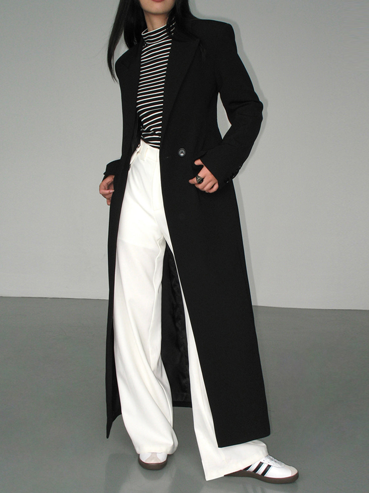 Women's long black tailored coat with lapels and one-button closure