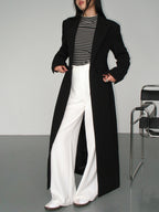 Women's long black tailored coat with lapels and one-button closure