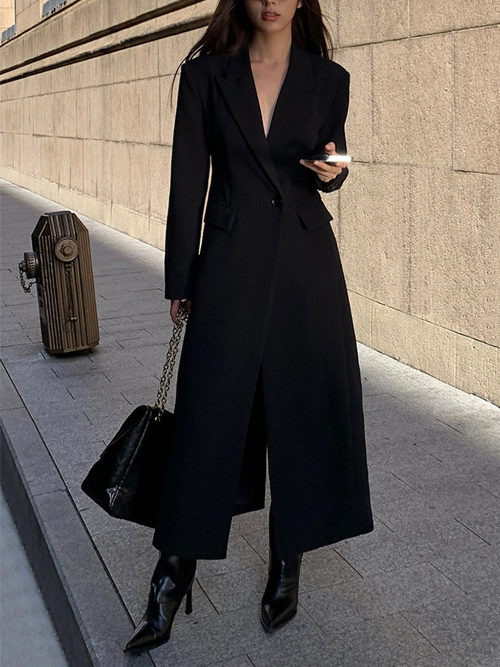 Women's long black tailored coat with lapels and one-button closure