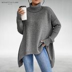 Women's oversized turtleneck knit tunic sweater with long sleeves and an asymmetric hem