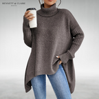 Women's oversized turtleneck knit tunic sweater with long sleeves and an asymmetric hem