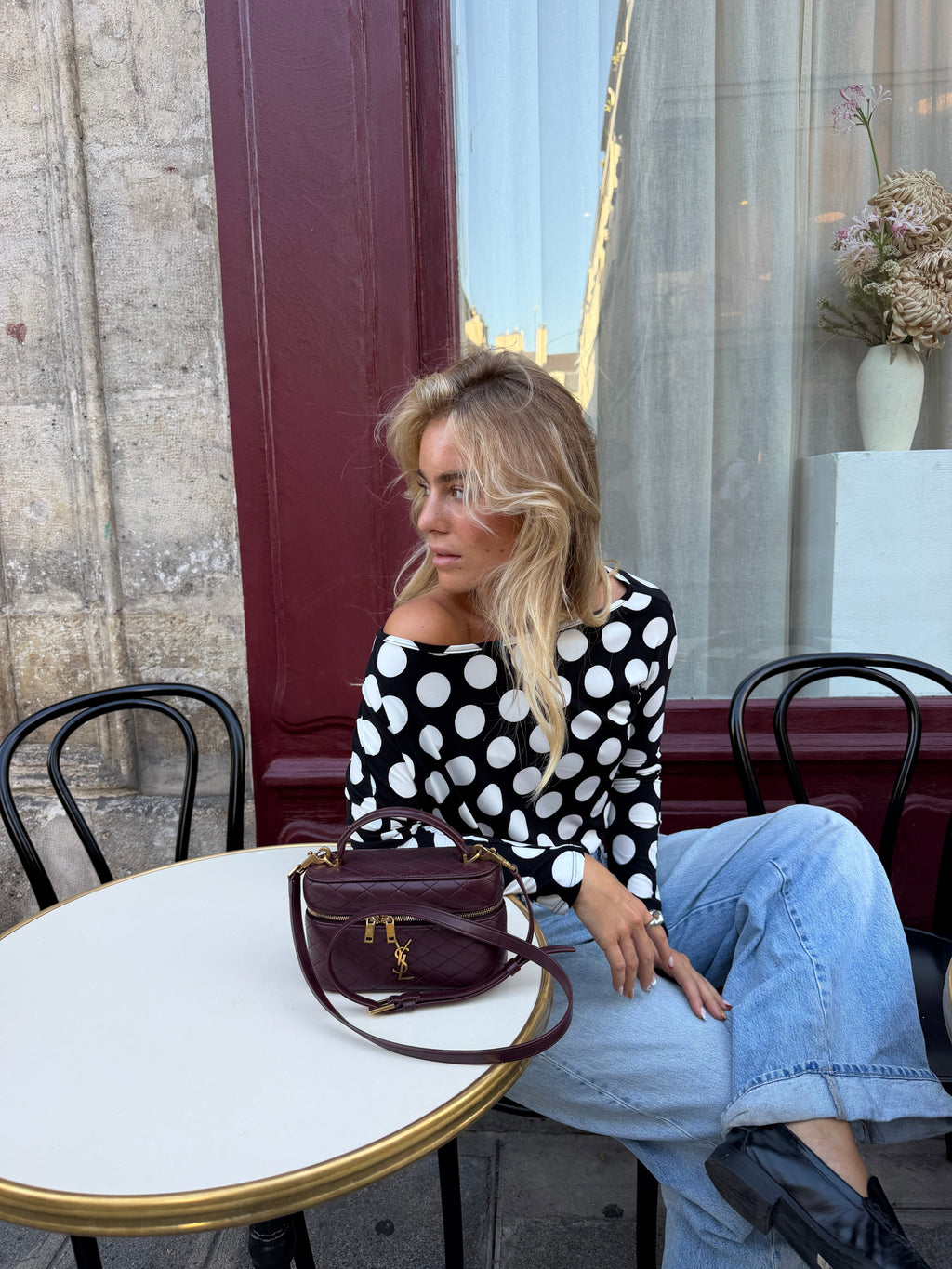 Women's black and white polka dot top with boat neckline and long sleeves