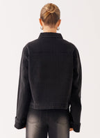 Woman wearing a charcoal oversized denim jacket with long sleeves and chest pockets