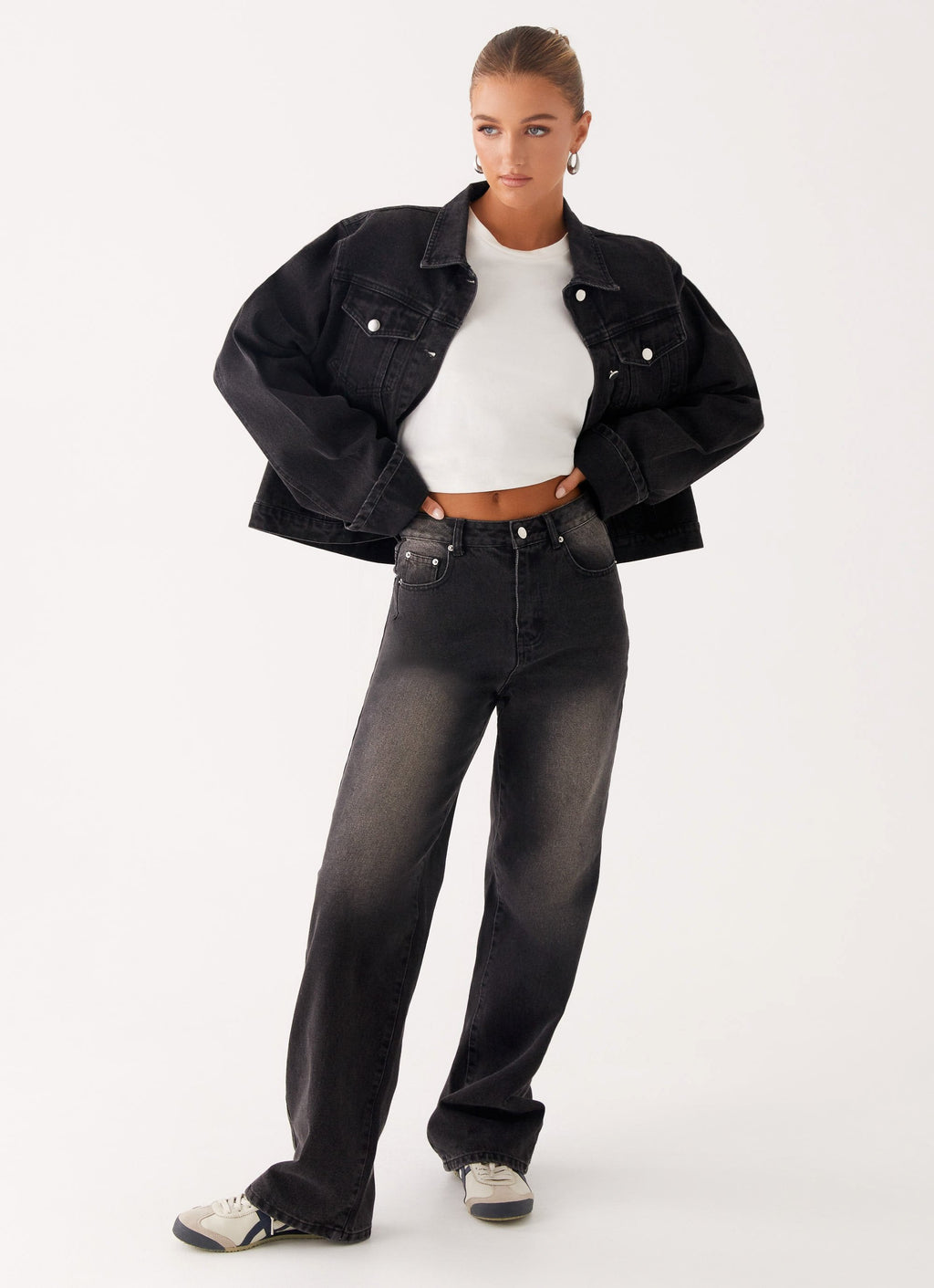 Woman wearing a charcoal oversized denim jacket with long sleeves and chest pockets