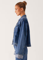 Women's oversized blue denim jacket with collar, long sleeves and front pockets