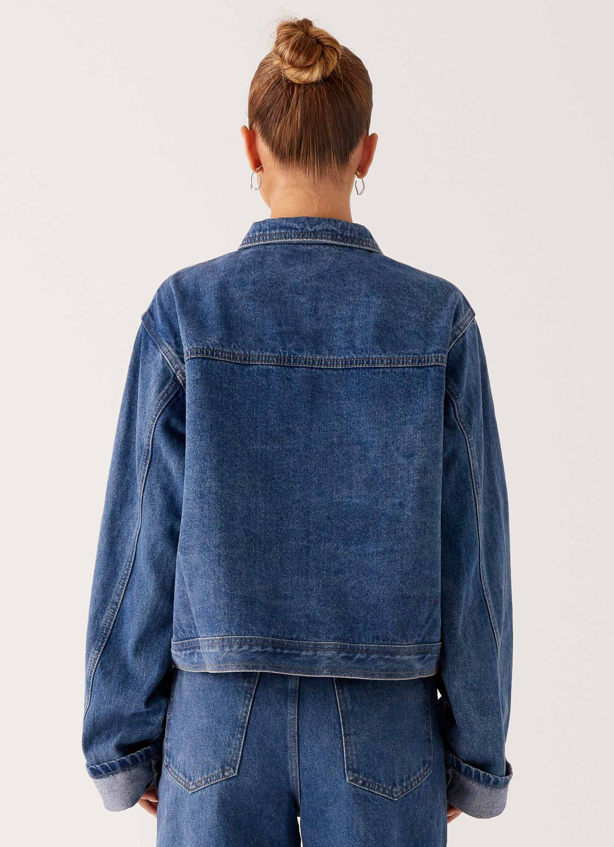 Women's oversized blue denim jacket with collar, long sleeves and front pockets