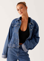 Women's oversized blue denim jacket with collar, long sleeves and front pockets