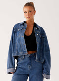 Women's oversized blue denim jacket with collar, long sleeves and front pockets