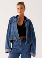 Women's oversized blue denim jacket with collar, long sleeves and front pockets