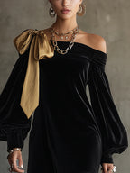 Black off-shoulder mini dress with long balloon sleeves and a gold shoulder bow