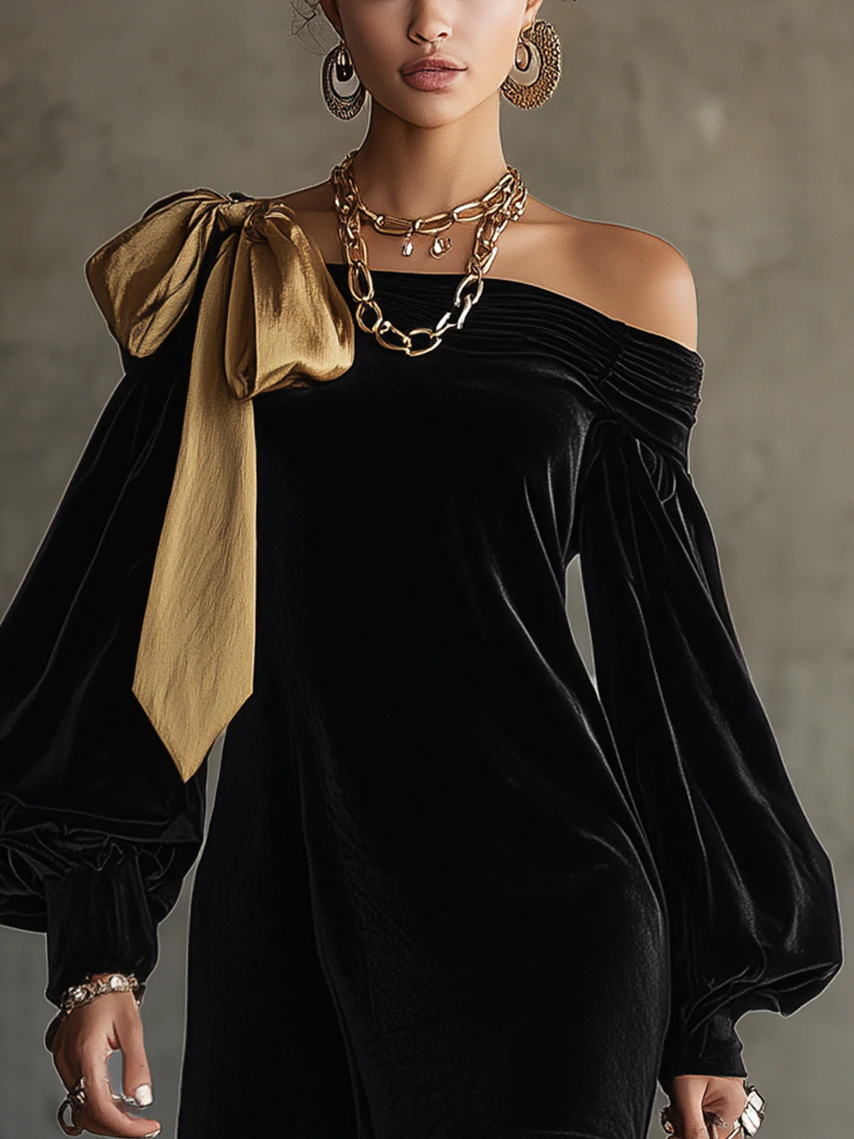 Black off-shoulder mini dress with long balloon sleeves and a gold shoulder bow