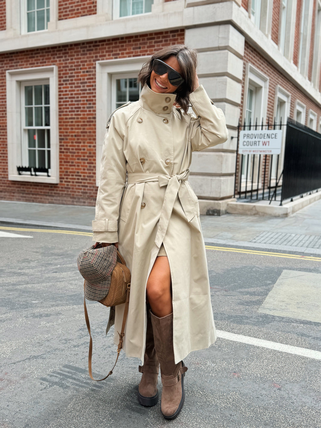Women's beige long trench coat with high collar, buttons and tied waist belt