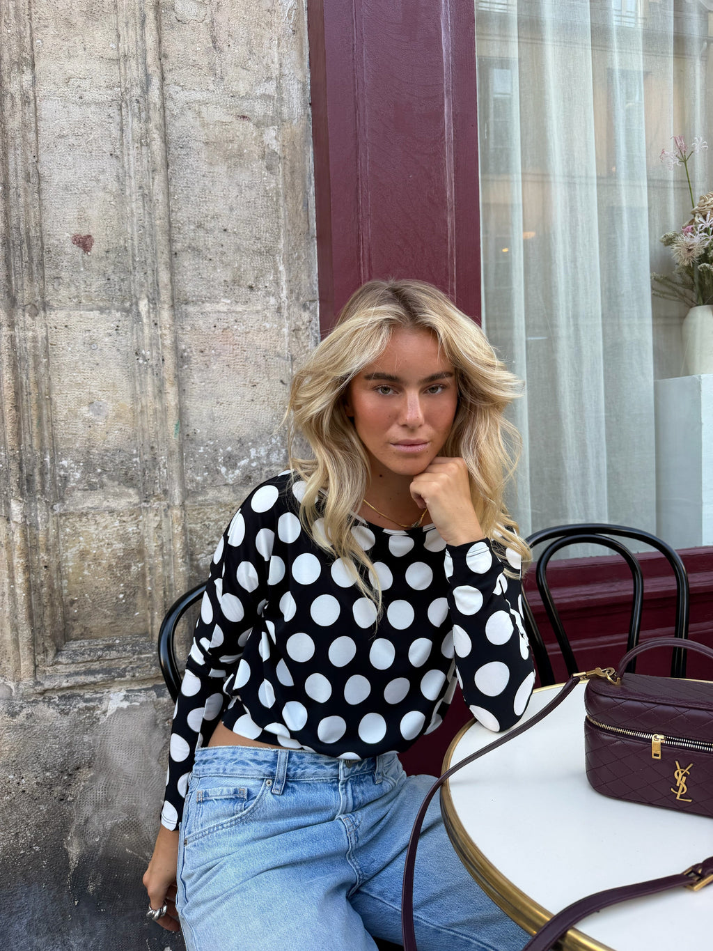 Women's black and white polka dot top with boat neckline and long sleeves
