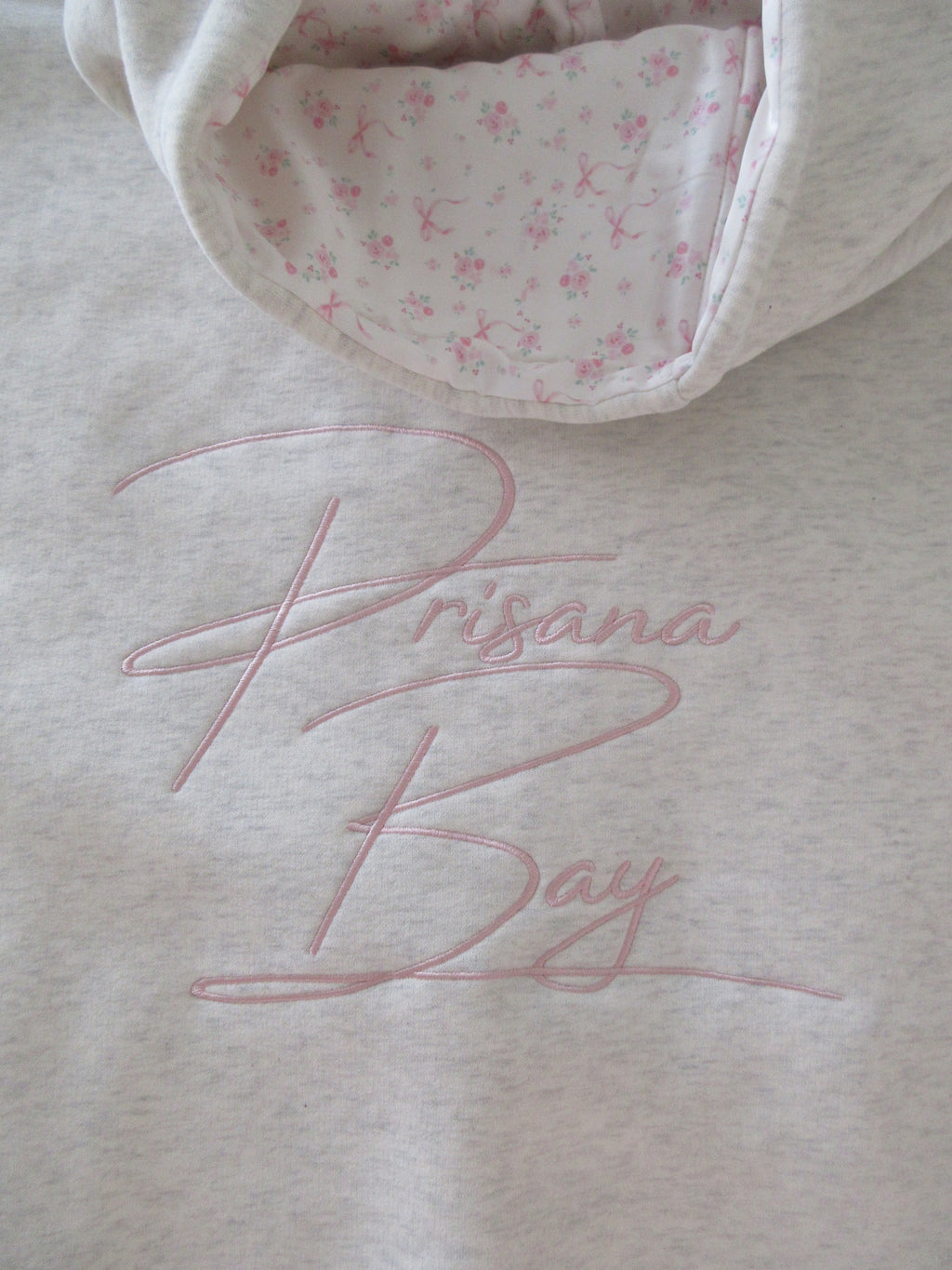 Women's light grey oversized hoodie with pink bow embroidery and floral-lined hood
