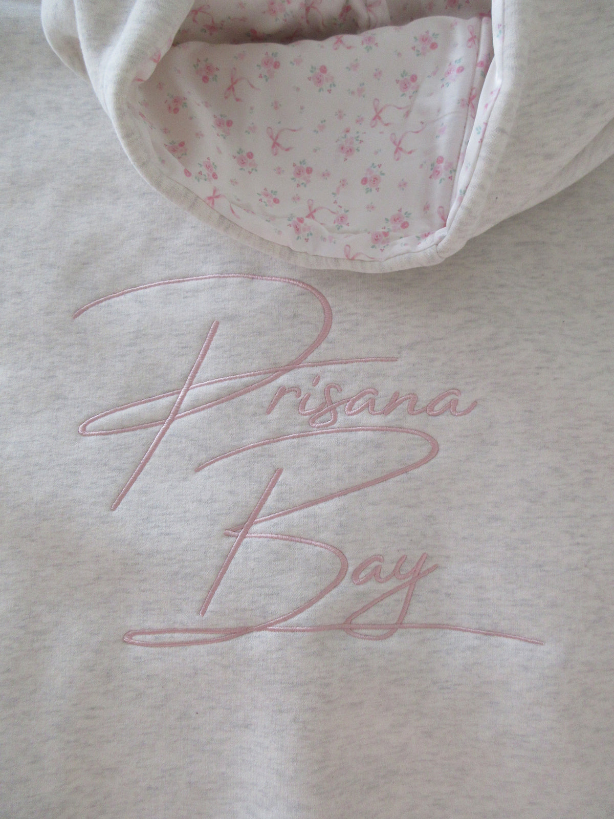 Women's light grey oversized hoodie with pink bow embroidery and floral-lined hood