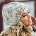 Women's chunky cable knit beanie with folded cuff and side badge