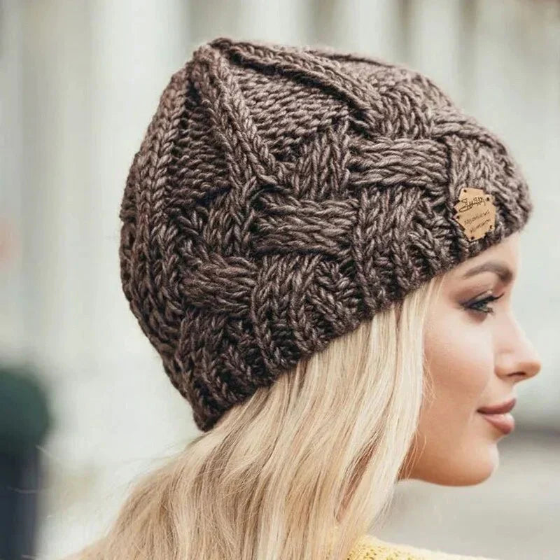 Women's chunky cable knit beanie with folded cuff and side badge