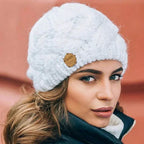 Women's chunky cable knit beanie with folded cuff and side badge