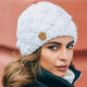 Women's chunky cable knit beanie with folded cuff and side badge