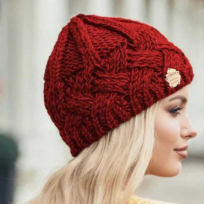 Women's chunky cable knit beanie with folded cuff and side badge