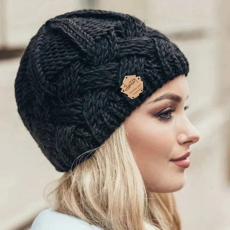 Women's chunky cable knit beanie with folded cuff and side badge