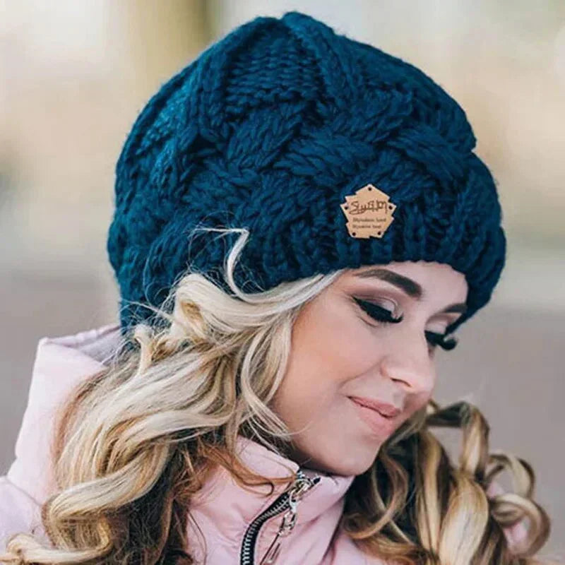 Women's chunky cable knit beanie with folded cuff and side badge