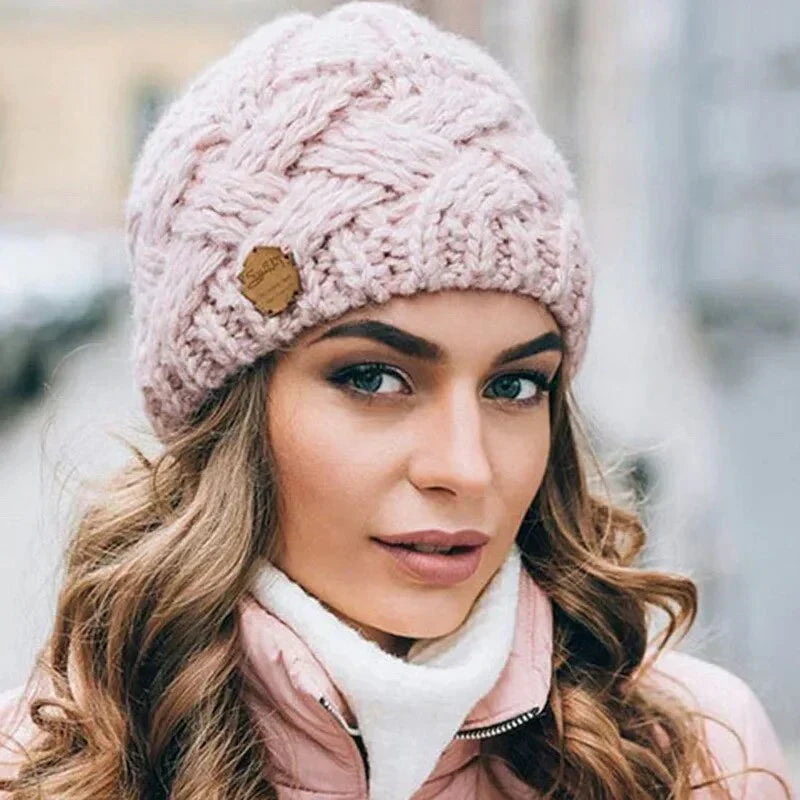 Women's chunky cable knit beanie with folded cuff and side badge