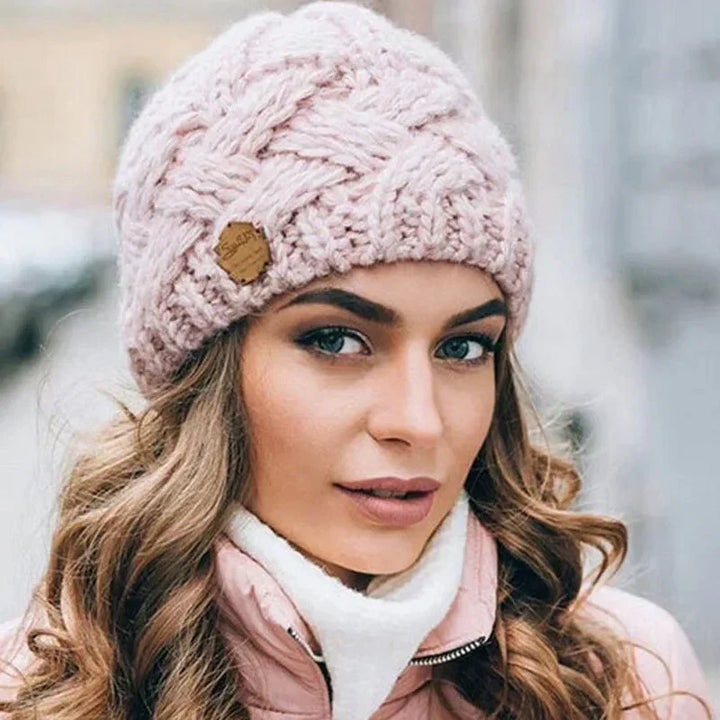 Women's chunky cable knit beanie with folded cuff and side badge