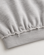 Grey cropped sweatshirt with distressed trims, long sleeves and cross flame graphic