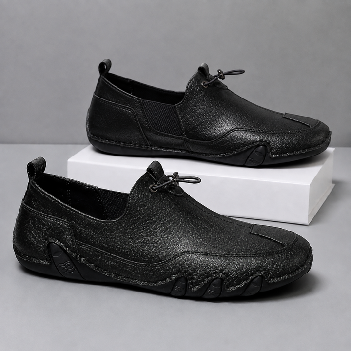 Men's slip-on moccasin loafers with toggle lace detail and flat segmented soles