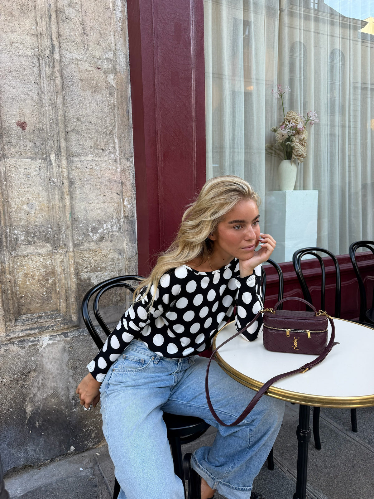 Women's black and white polka dot top with boat neckline and long sleeves